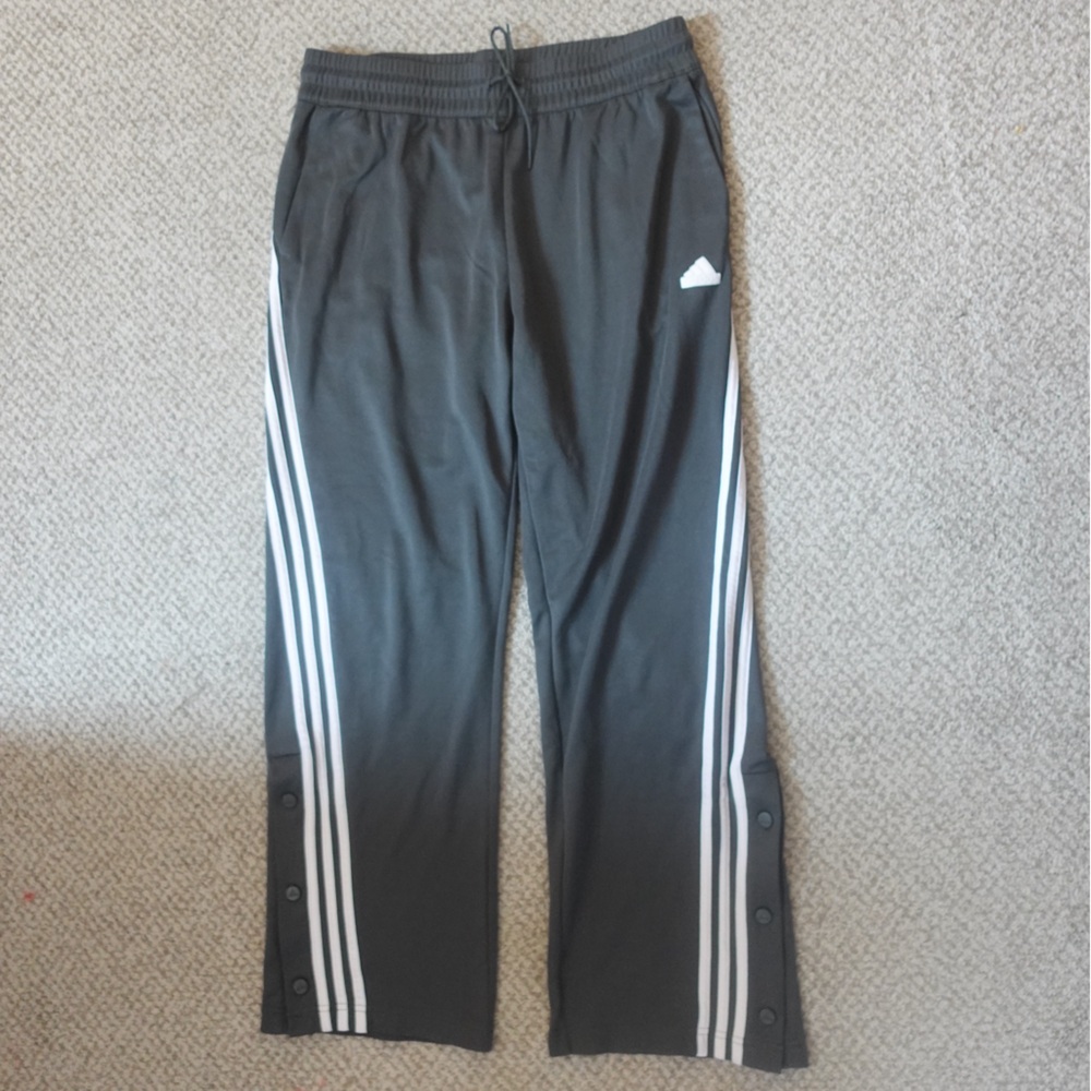 Green adidas track pants with white stripes